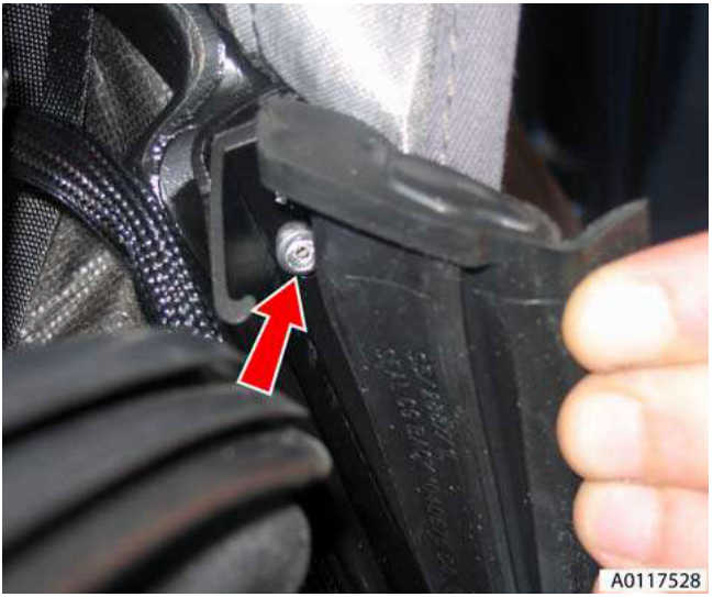 Close-up view of a drill bit drilling out a pop-rivet securing the rear seal assembly to a B-post