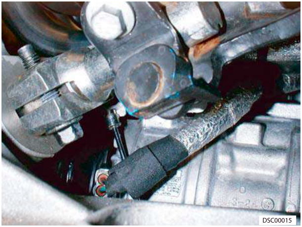 Close-up of engine components showing bolt and pipe connection