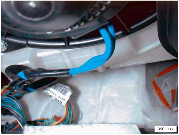 Photo showing electrical multiplugs and wiring harness located inside the vehicle near the instrument panel