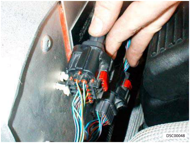 Hand connecting multiplug with wires in engine bay
