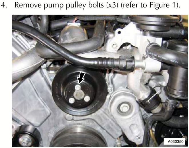 View of the water pump pulley area showing three bolts indicated by arrows on the black circular component.