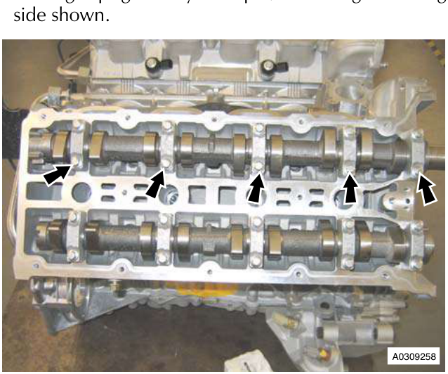 Engine block with camshafts and arrows pointing to bolt positions