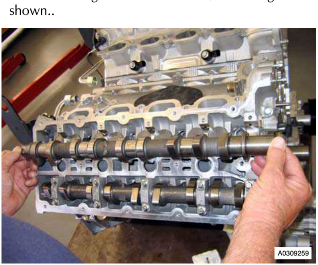Engine block with hand removing a camshaft