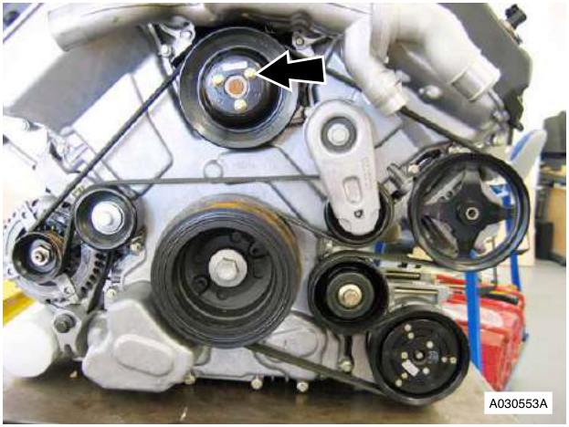 Engine with timing cover removed, showing water pump pulley and drive belt.