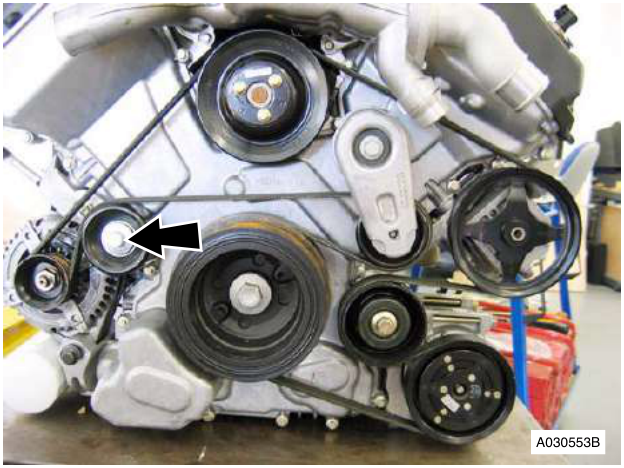 Engine with belt and pulleys, arrow pointing to a pulley