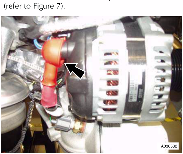 Alternator with red battery cable and terminal cover, arrow pointing to a nut