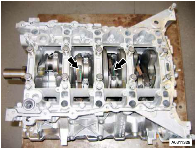 Engine block with arrows pointing to bolts securing the bedplate