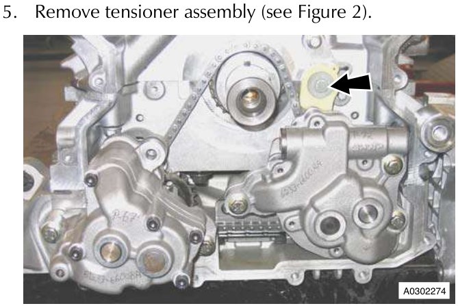 Engine block showing tensioner assembly with arrow pointing to it