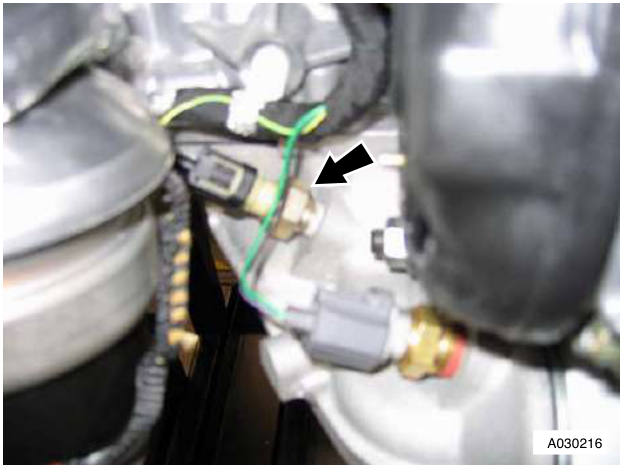 Engine block showing multiplug connected to oil pressure sensor with arrow pointing to it