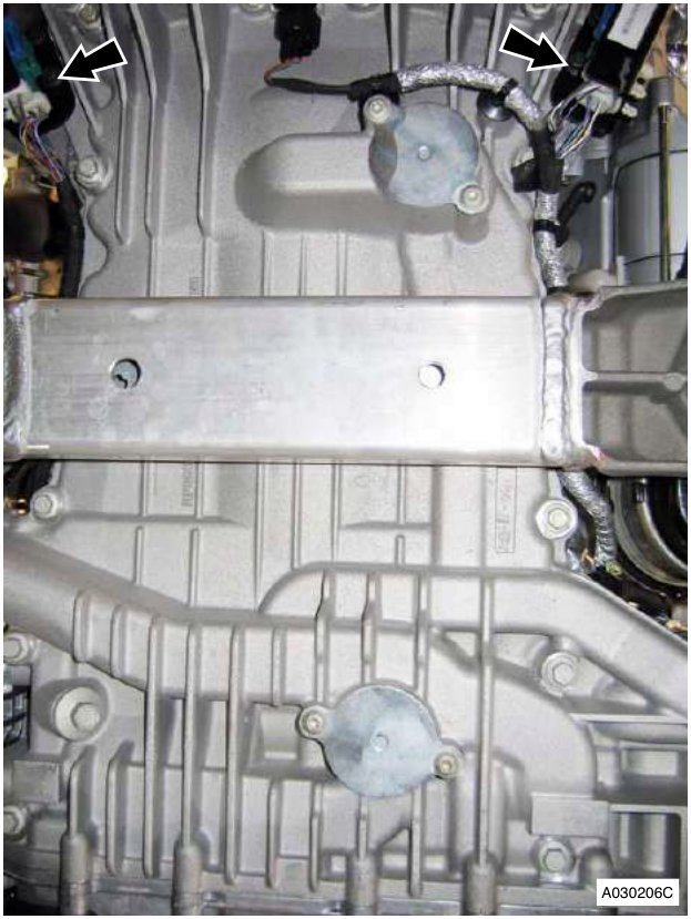 Engine sump area with arrows pointing to bolts securing LH and RH HEGO sensor multiplug brackets