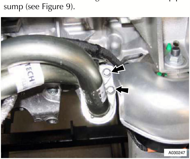 Close-up of oil pipes connected to sump with arrows pointing to the bolts