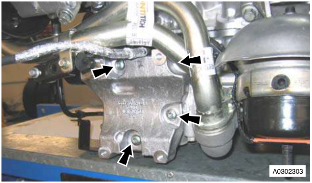 A/C compressor mounting bracket with arrows pointing to the Torx bolts