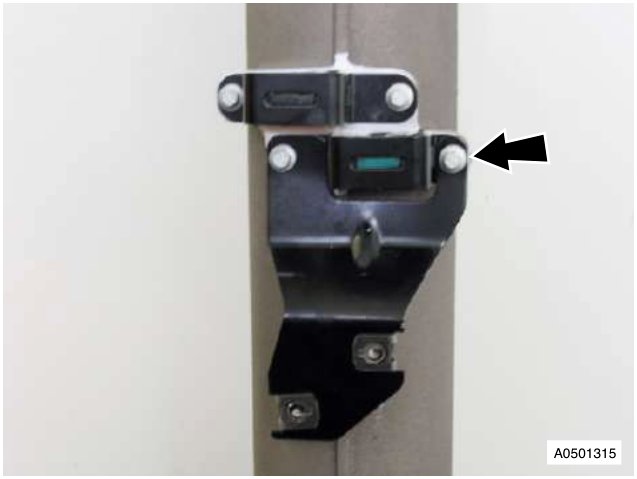 Close-up photograph of an exhaust mounting bracket secured to a vertical metal tube, with a black arrow pointing to the upper fastener.