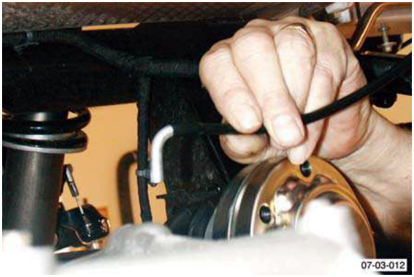 Hand disconnecting a breather pipe from a transaxle component, labeled F4.