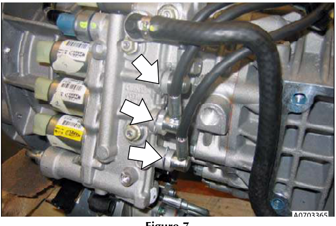 Hoses connected to a valve block with clips being removed.