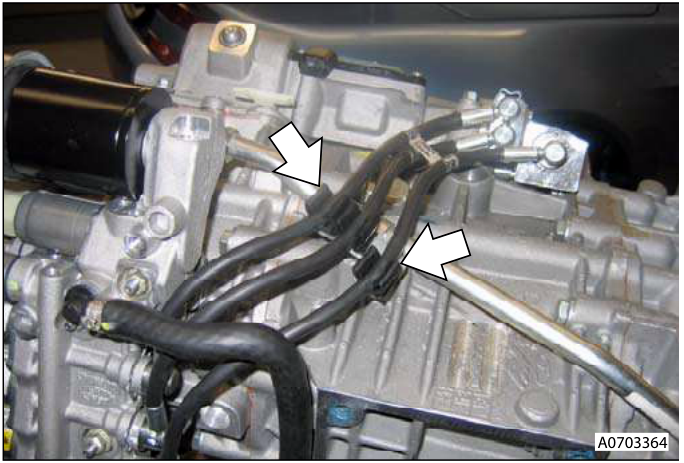 Hoses released from support clips on a transmission assembly.