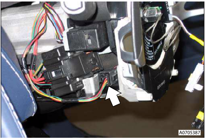 Close-up of disconnected electrical connector with arrow pointing to it