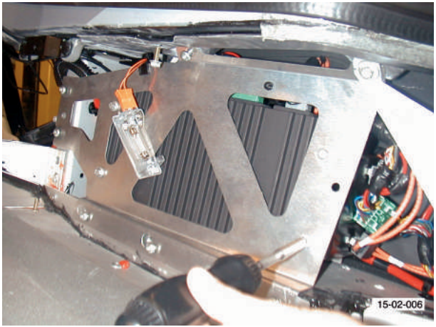 Amplifier bracket with mounting plate and wiring, hands installing or removing components.