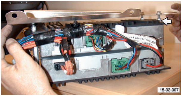 Power amplifier unit with multiplugs and wiring, hands holding the unit.