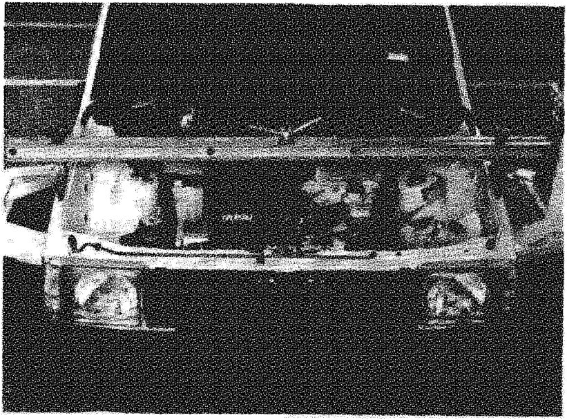 View from underneath the vehicle showing the engine and gearbox supported by a cross member bar spanning across the chassis.