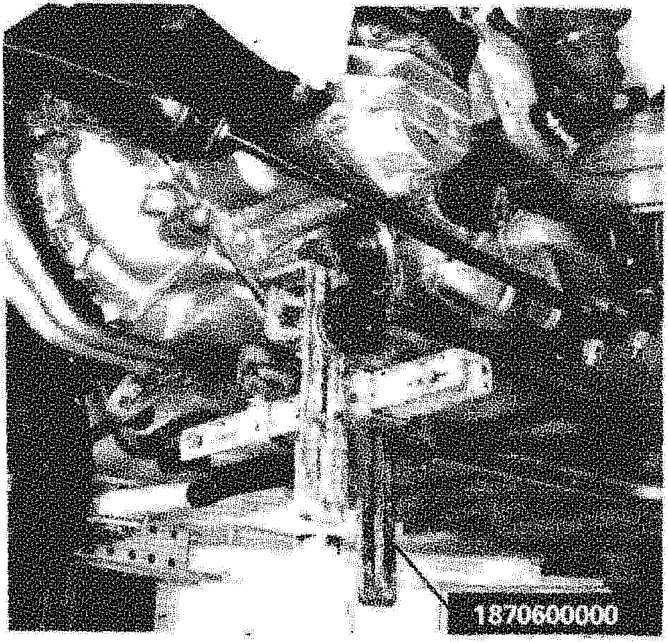 Close-up view of the gearbox-differential assembly being supported by a hydraulic jack with support tool 1870600000 during removal.