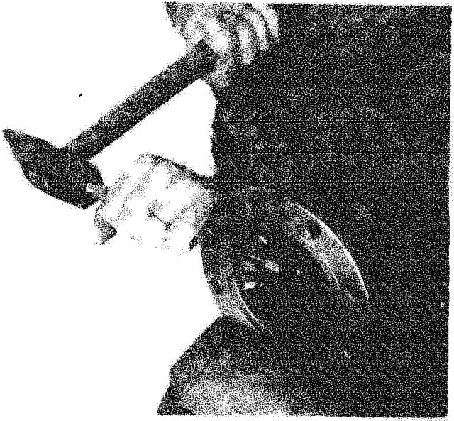Mechanic using a hammer and drift to dismantle the differential casing