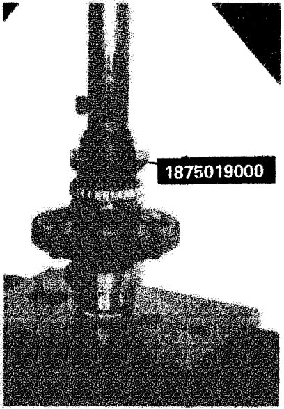 Photograph showing a bearing being pressed onto a differential casing using a press tool. The part number 1875019000 is labeled on the tool.
