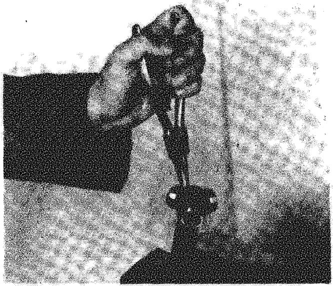 A hand using a tool to remove or adjust a three-lobe joint on a drive shaft