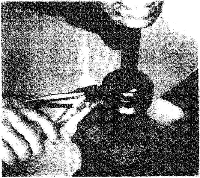 A person using a tool to remove or refit a constant velocity joint on a drive shaft