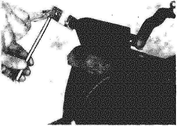 A hand using a tool to manipulate the gear engagement rod at the relay mounting