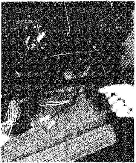 A hand removing the radio console from the dashboard