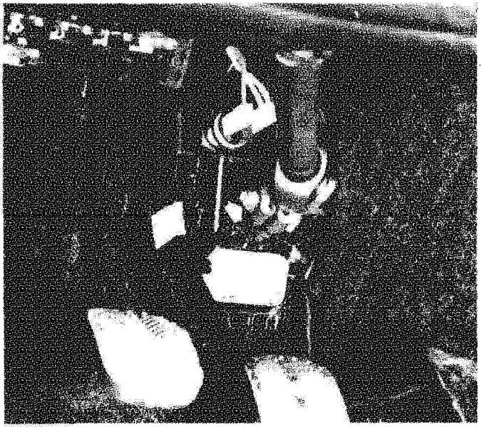View of the lower steering shaft connected to the steering box pinion area under the vehicle dashboard.