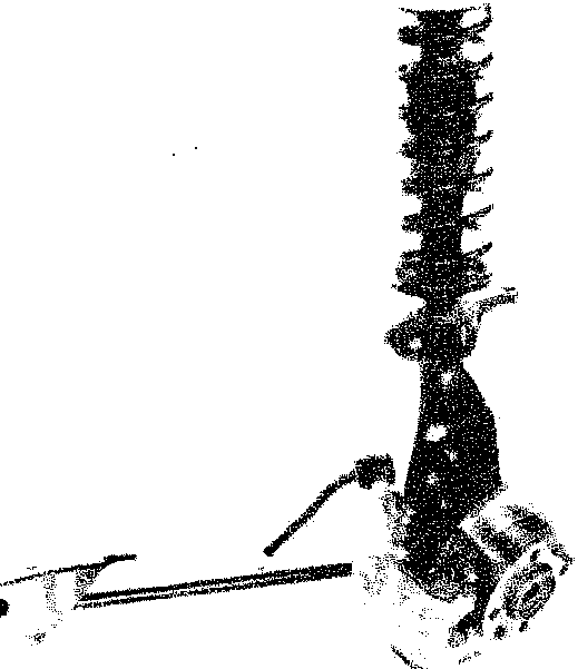 Diagram of the front suspension assembly including shock absorber, coil spring, and steering knuckle