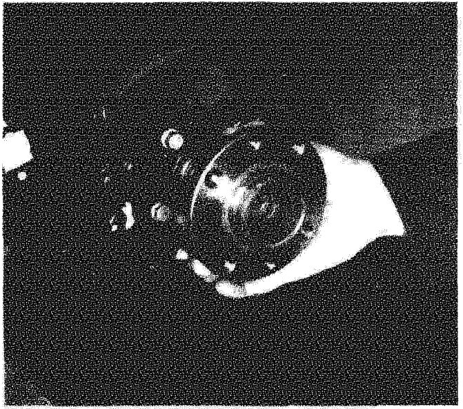 A hand pulling the wheel hub assembly away from the vehicle's mounting point