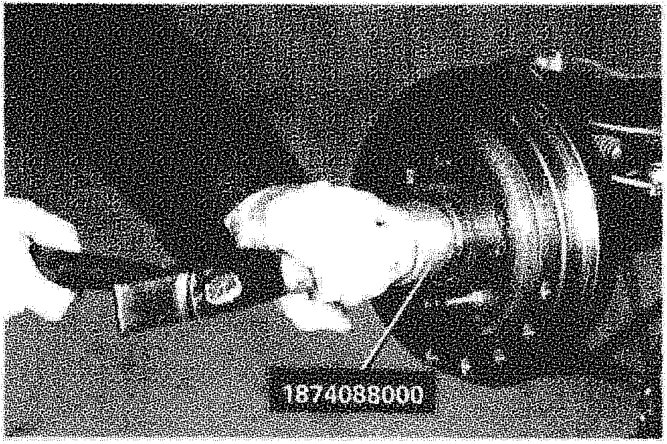 A hand using a tool to fit or remove a wheel hub cap