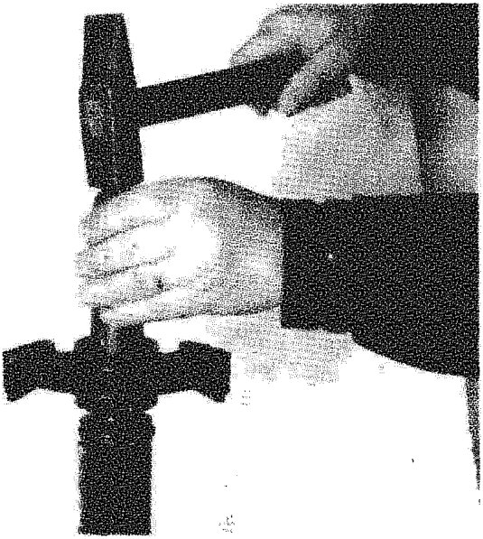 Fitting flexible mounting (complete with bearing) on central shaft using a drift and hammer.