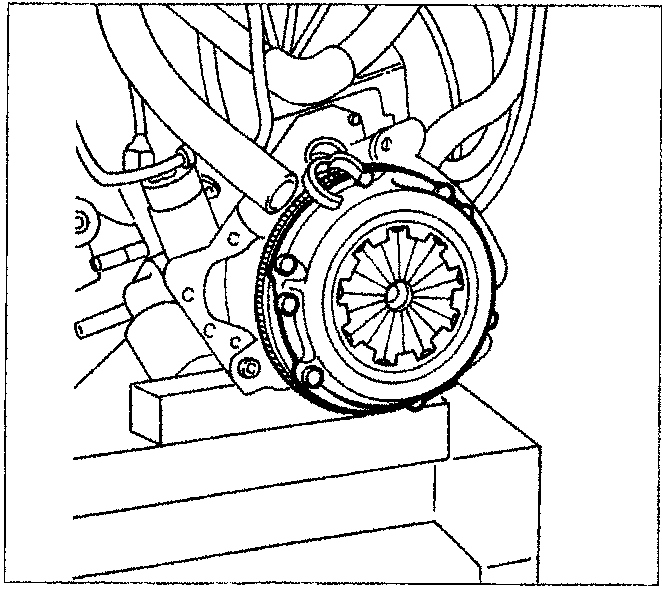 Diagram showing the clutch assembly being removed from the engine flywheel