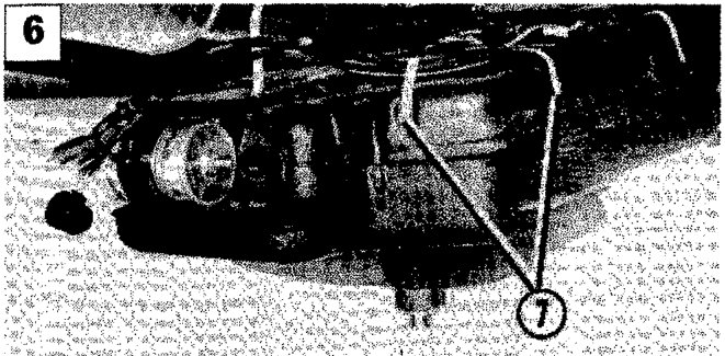 Image showing the fuel tank supported by a strap with callout number 7 indicating the retaining band.