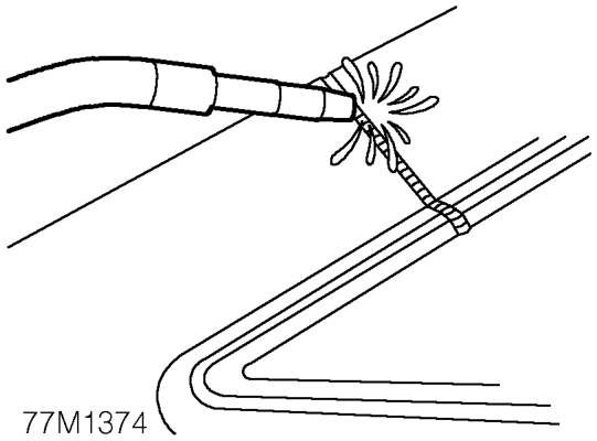 Dress MIG tack welds using a sander with 36 grit disc, or a belt-type sander where access 