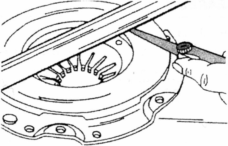 Checking the clutch pressure plate for distortion.