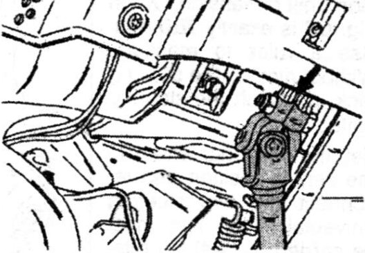 The arrow shows the clamp bolt of the universal joint between the upper and lower steering shaft.