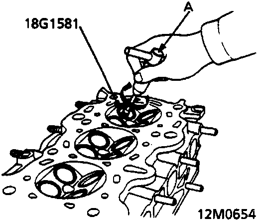 Illustration of a hand using a reamer handle to work on a cylinder head valve guide.