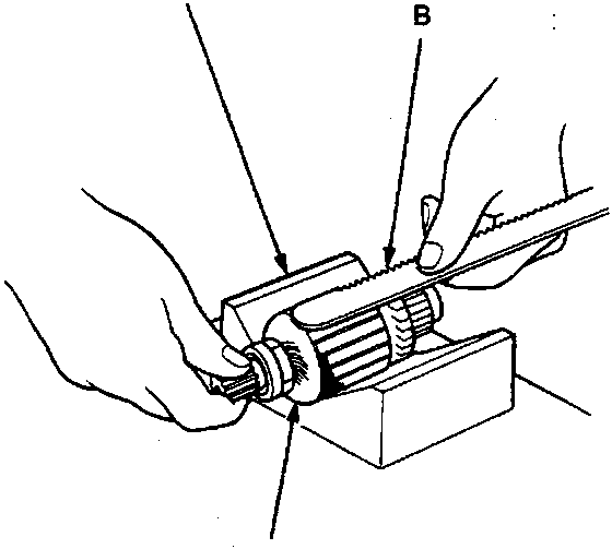 Hands holding a hacksaw blade against an armature core placed on an armature tester block