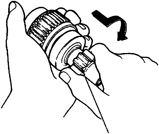 Hand holding a starter drive gear assembly to check clutch movement