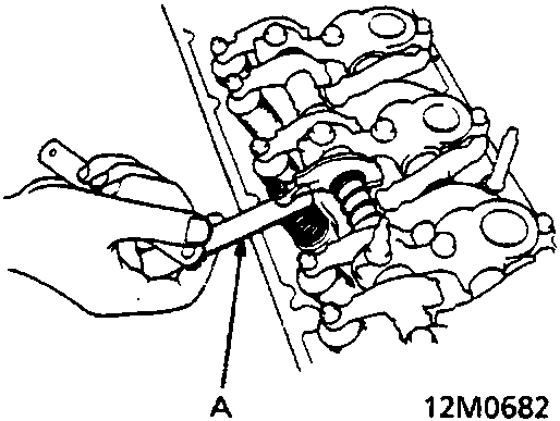 Diagram showing a hand using a feeler gauge to check valve clearance on the cylinder head