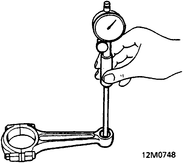 A dial indicator measuring the interference between a gudgeon pin and the small end of a connecting rod (12M0748).