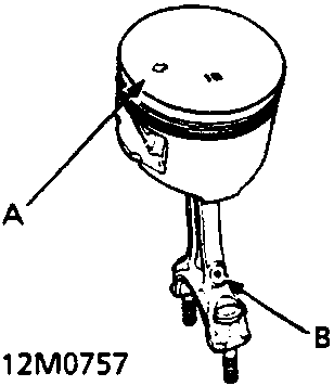 Diagram of a piston and connecting rod showing an arrow on the piston crown and the connecting rod oil hole