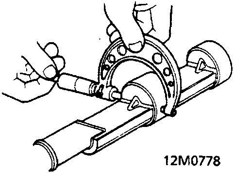Diagram showing a hand using a micrometer to measure a journal on a balancer shaft assembly