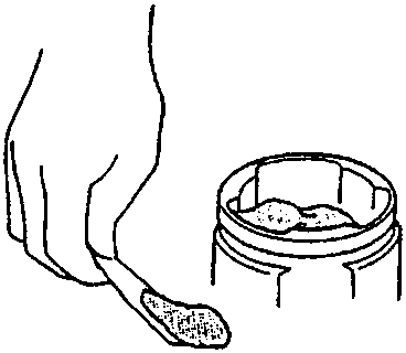 Illustration of a hand using a tool to pack grease into a driveshaft joint component.