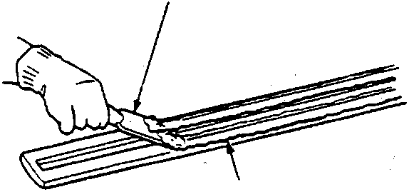 Diagram showing a hand using a putty knife labeled A to scrape adhesive tape labeled B from a component.